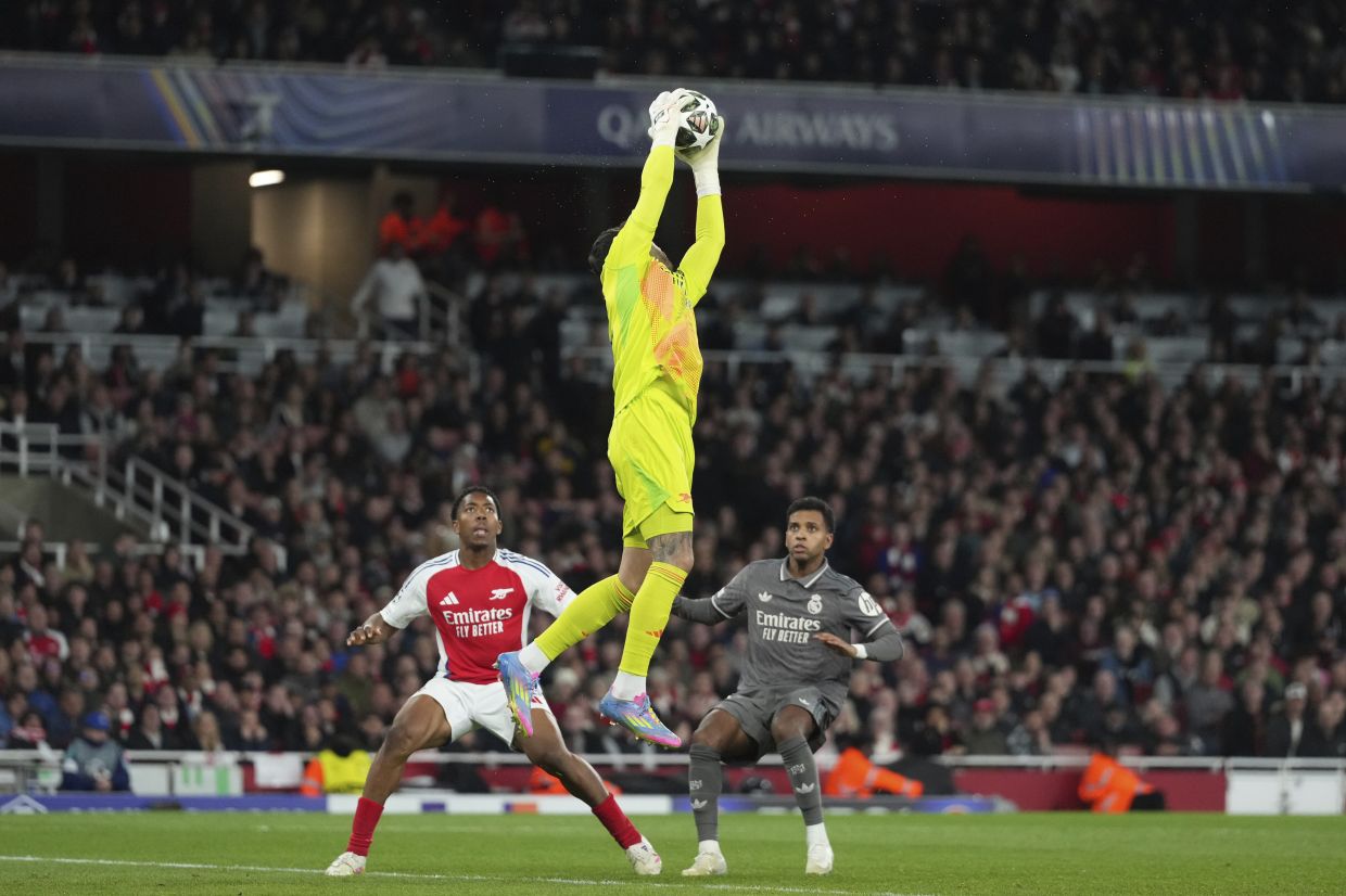 Arsenal goalkeeper David Raya catches the ball as Real’s Rodrygo and Arsenal’s Myles Lewis-Skelly look on. — AP