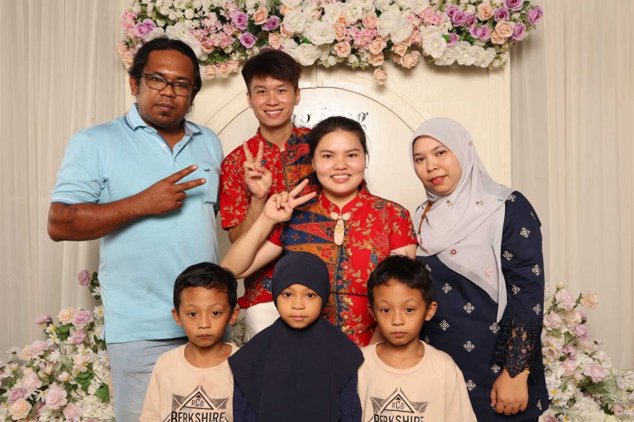 The bridal couple Khaw Fong Fong (back row, second from right) and Cheah Jiang Wei (back row, second from left) with friends who attended the kenduri, locally referred to as makan gulai.