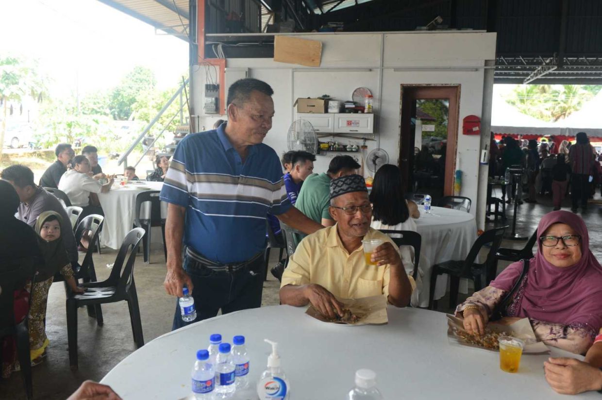 Khaw Beow Khoon, better known as Munil (standing) catching up with business associates and old friends that attended his daughter's wedding banquet.