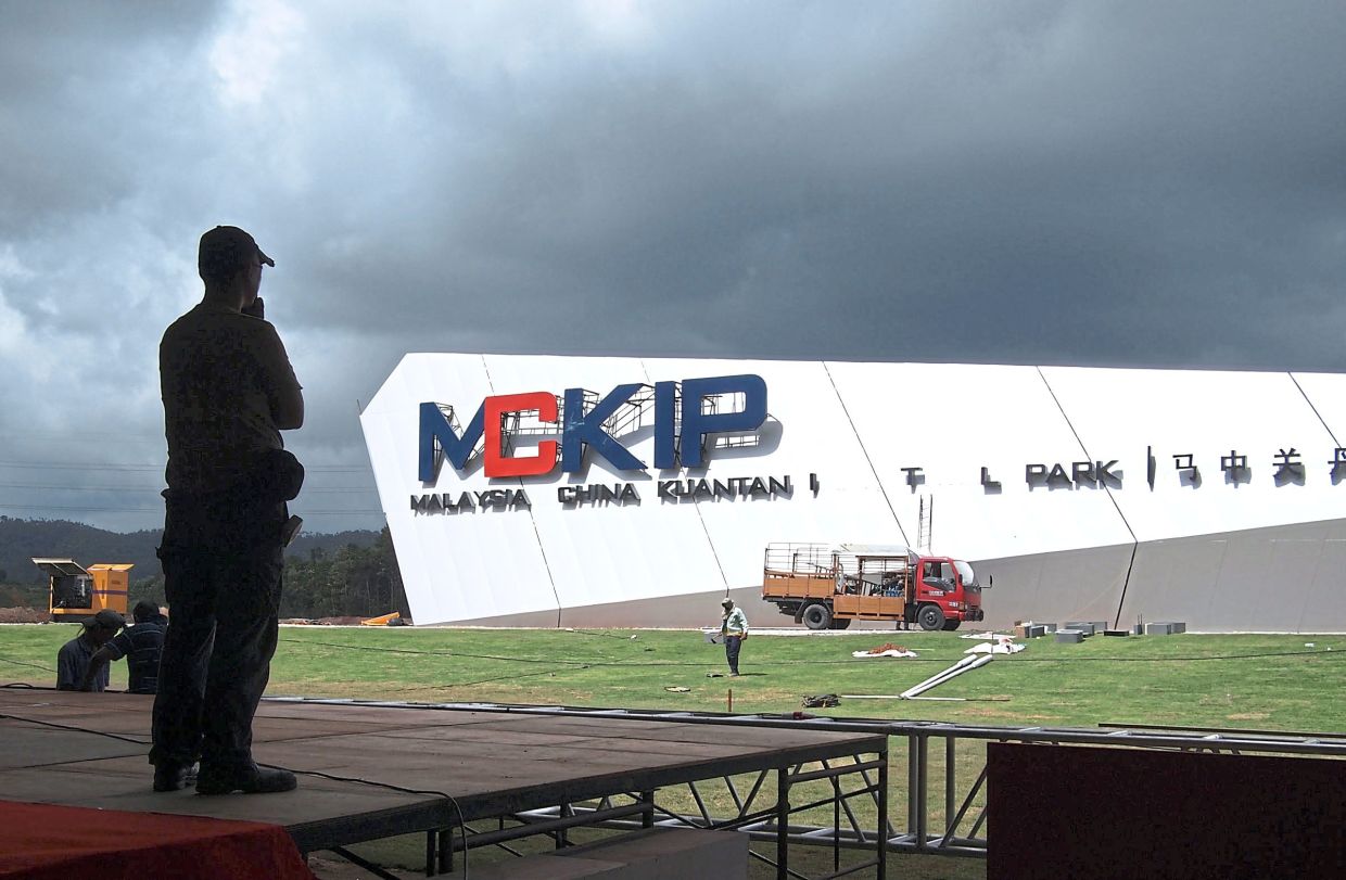 A worker supervising the final touches on the Malaysia-China Kuantan Industrial Park (MCKIP) signboard before the launch of the park in Pahang.