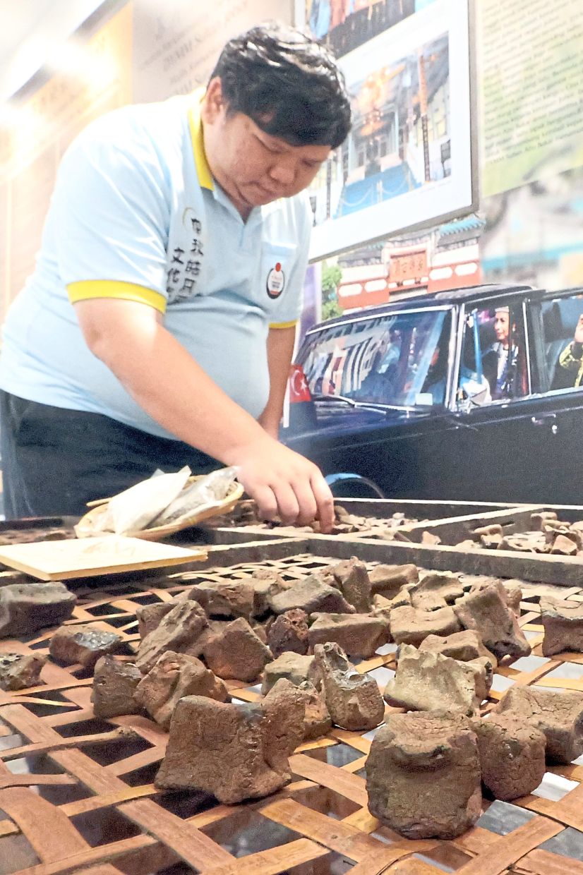 Lee arranging pieces of gambir, which was once widely cultivated in Johor, for display at the museum.