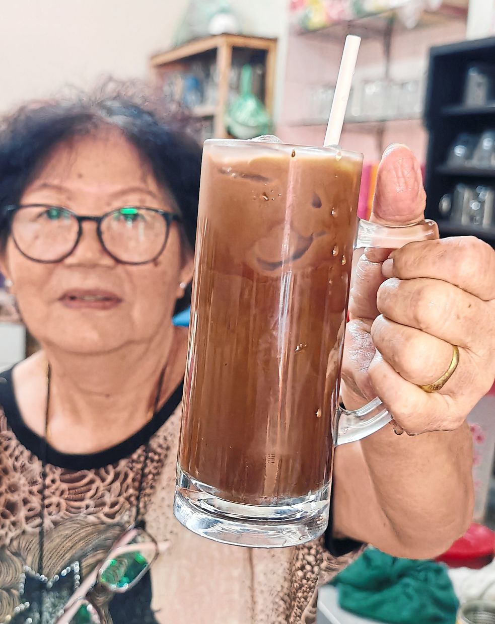 Northern specialty: Yap holding a glass of ‘hor ka sai’, which is prepared by mixing black coffee and Milo with condensed and evaporated milk. — KT GOH/The Star