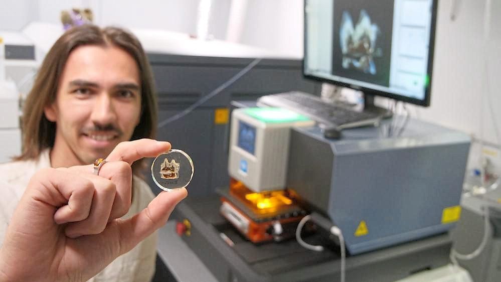 Lead researcher and UOW PhD candidate Chris Laurikainen Gaete with a tooth fossil from a giant kangaroo. Photo AFP