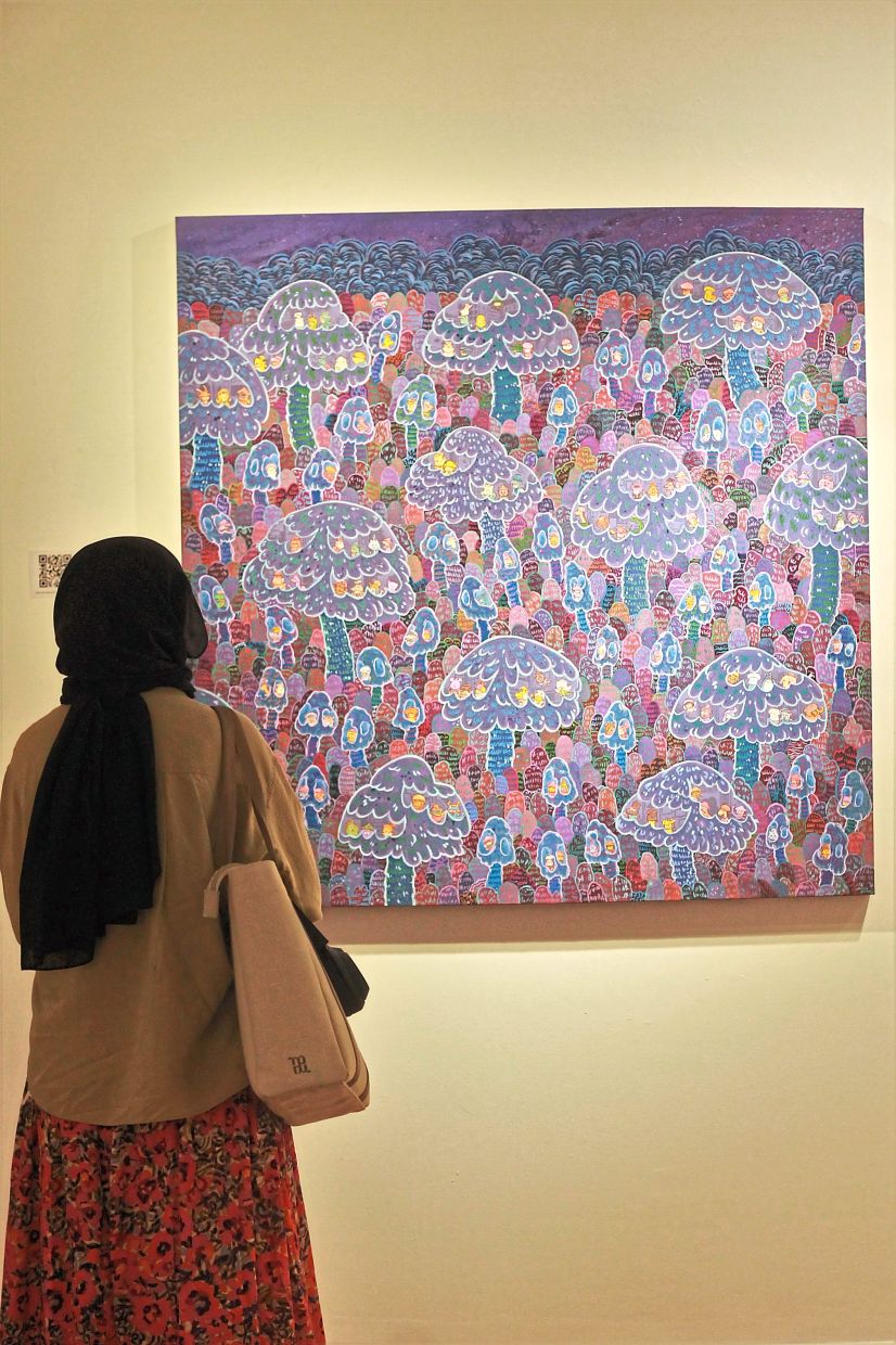 A visitor admires Aimman's 'From Jaws To Claws', inspired by the beloved Sang Kancil tales. Photo: The Star/M. Irsyad 