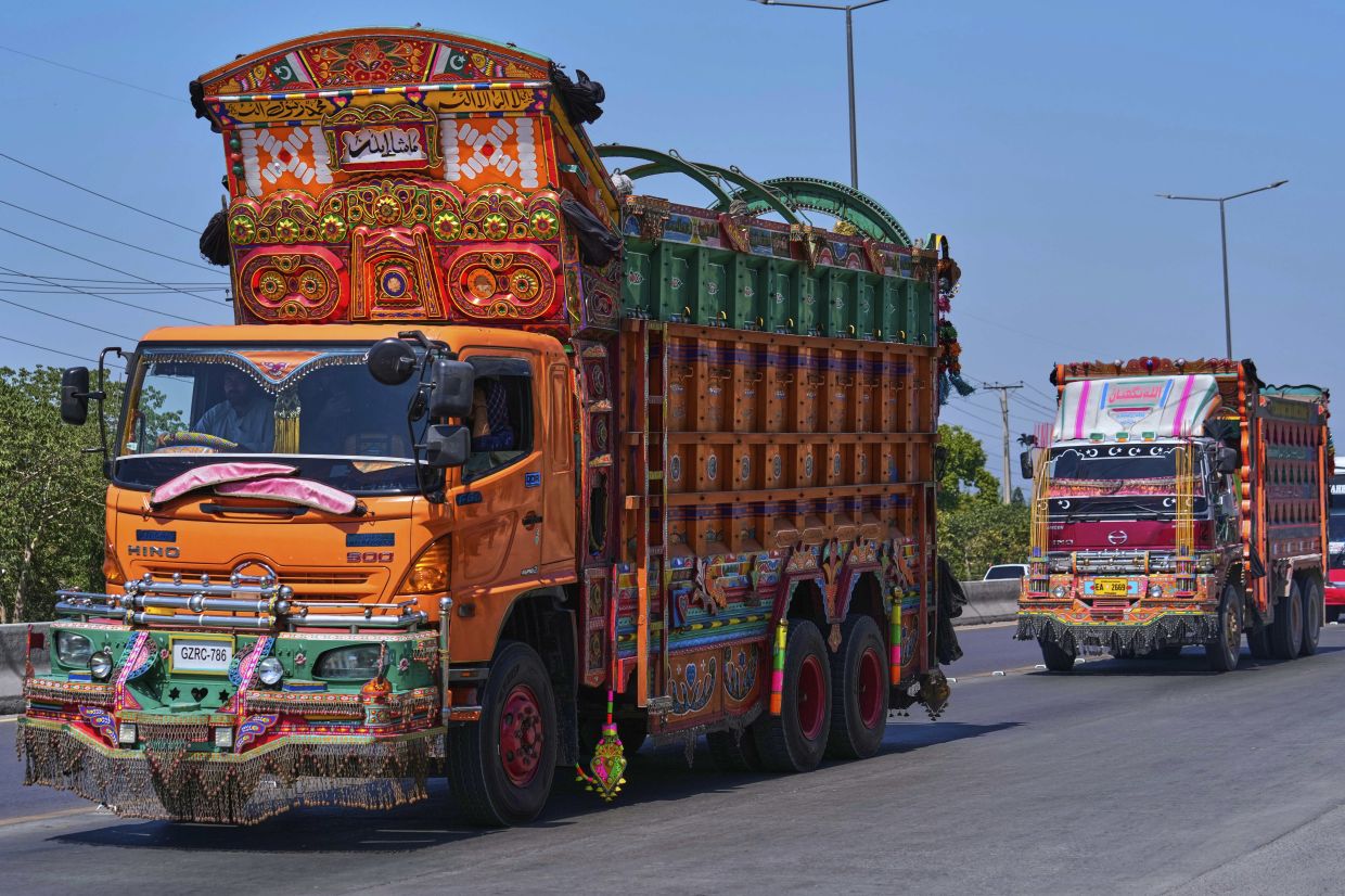 Trucks decorated with artwork drive along a highway on the outskirts of Islamabad, Pakistan. Photo: AP 