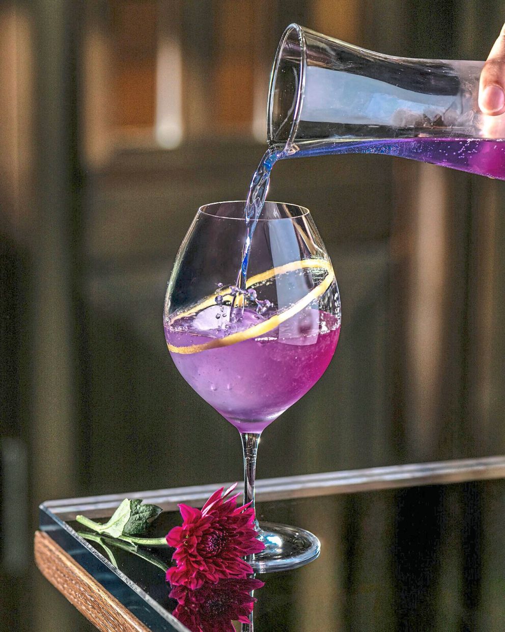 Cosmos is poured into a glass with a ring of edible glitter.