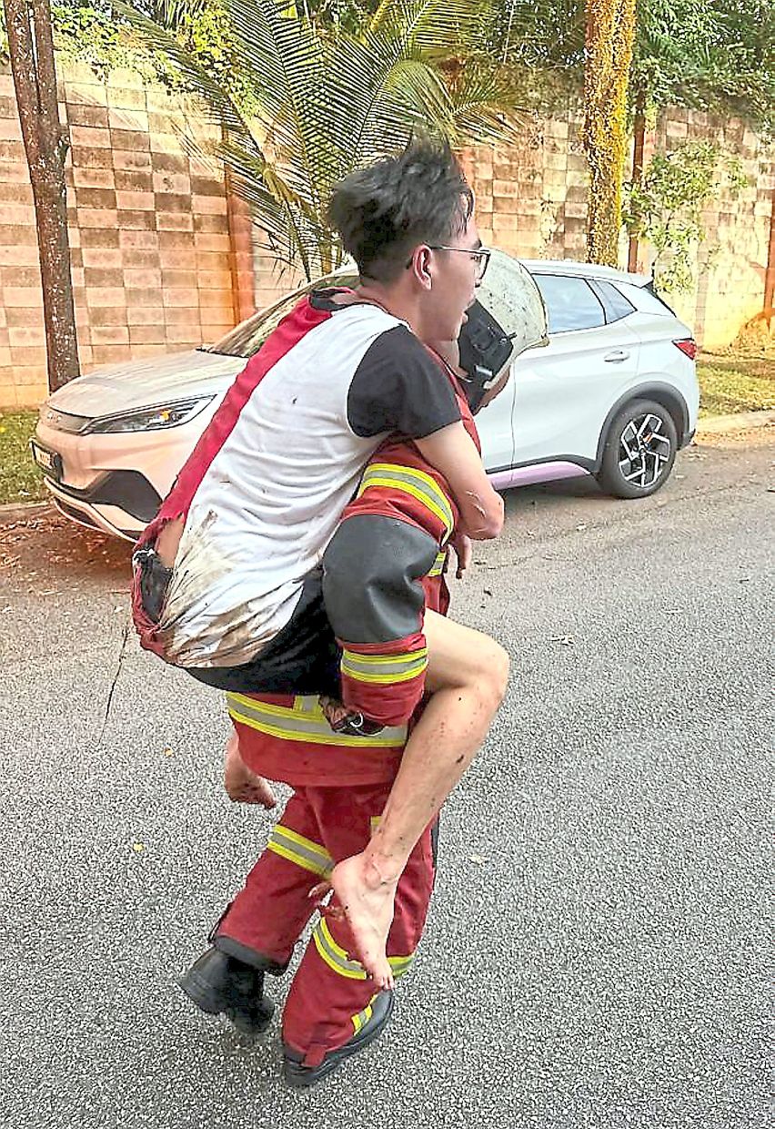 A fireman rescuing a resident during the fire at Putra Heights in Selangor on April 1.