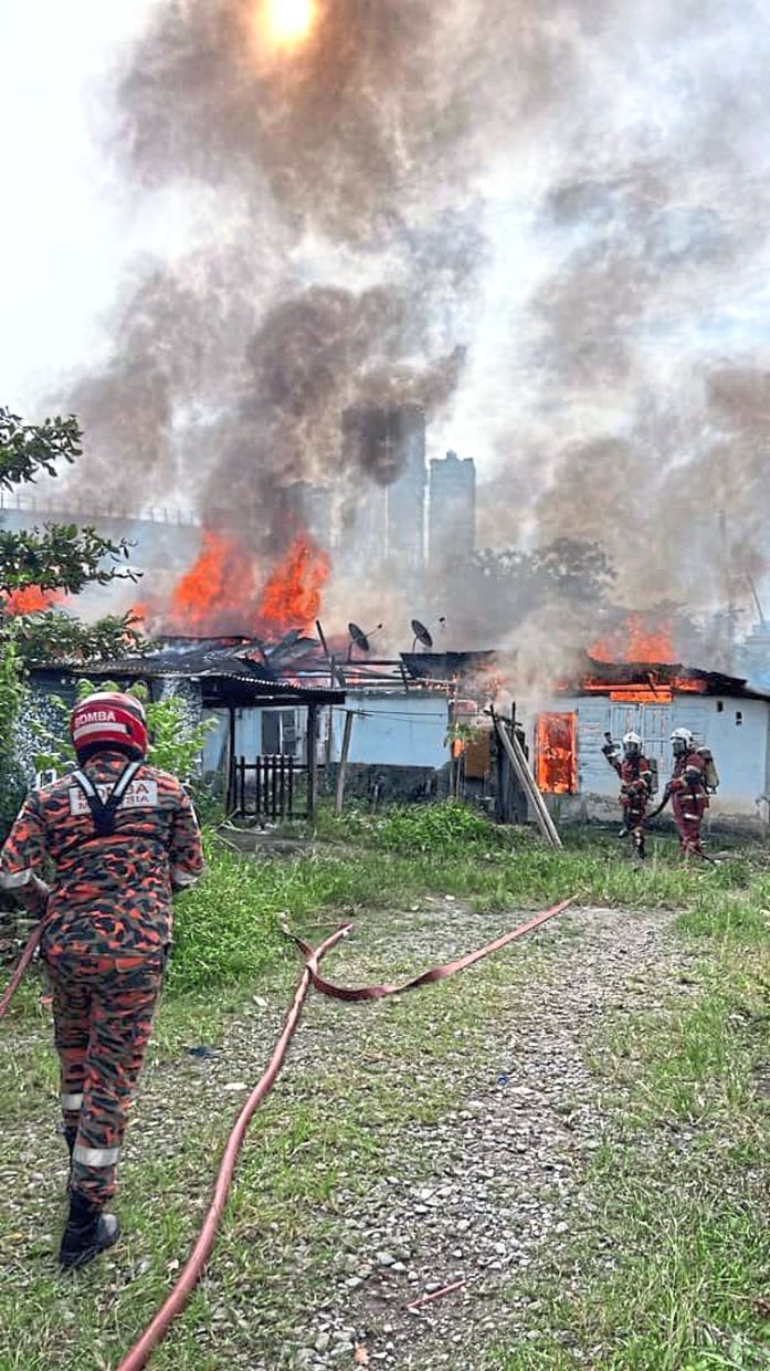 Firemen putting out a blaze at a house in Johor Baru.