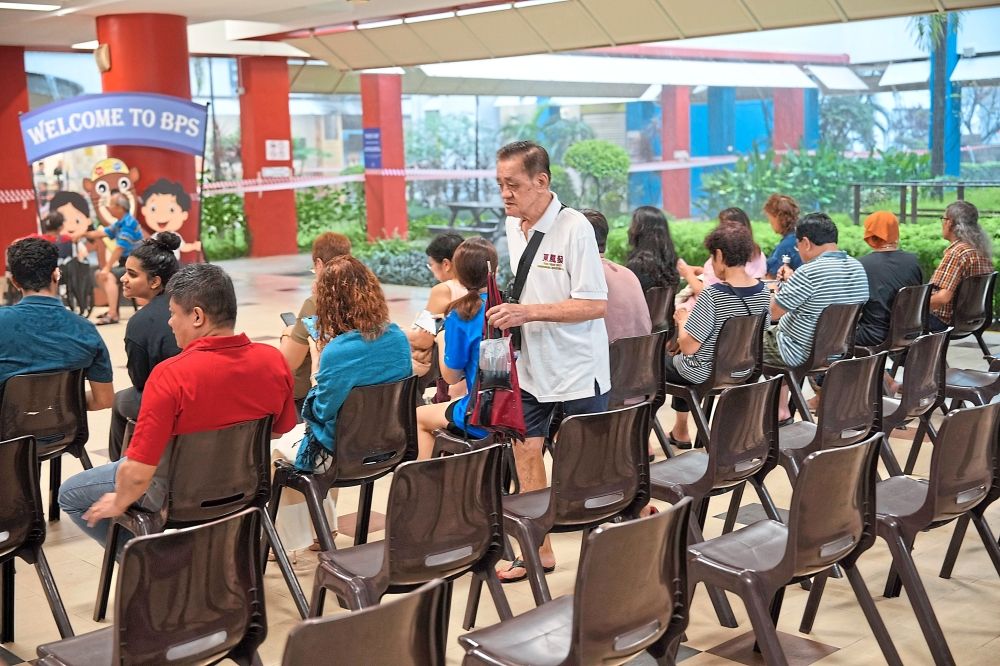 Doing their part: Singaporeans arriving to cast their votes. — AP