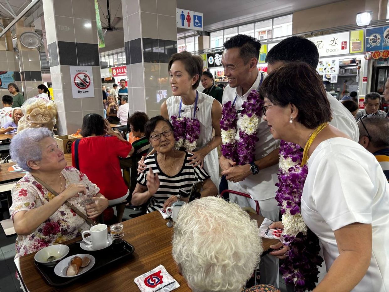 At Beo Crescent Market in Jalan Besar GRC, supporters welcomed the PAP team with orchid garlands a the MP-elects turned up to thank voters for their support. - ST