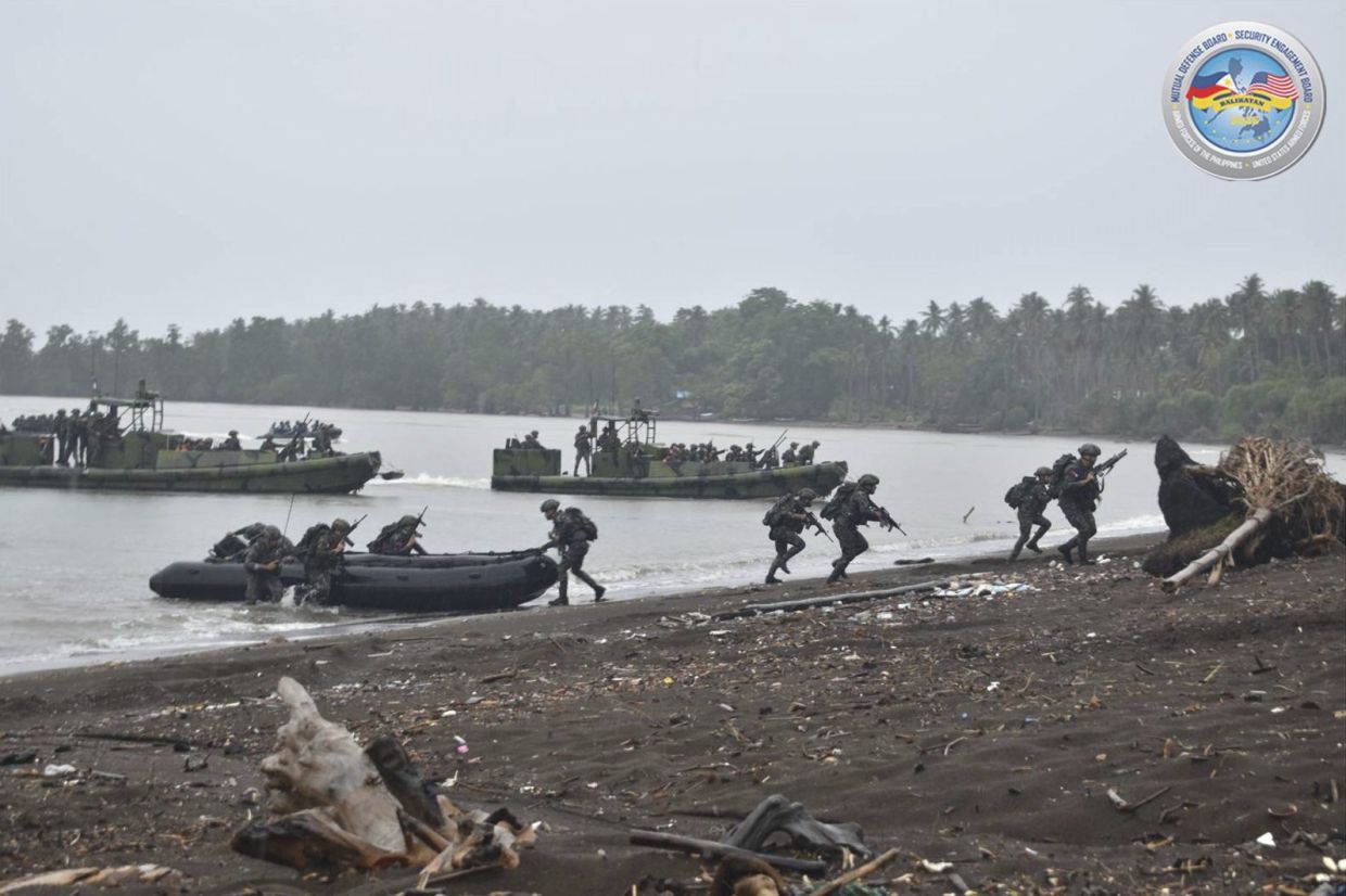 In this photo provided by the Armed Forces of the Philippines Public Affairs Office (PAO), Philippine Marines participate in amphibious landing exercise as part of a joint US-Philippines military exercises called Balikatan or - shoulder to shoulder -- in Balabac, Palawan province, Philippines. -- Armed Forces of the Philippines PAO via AP