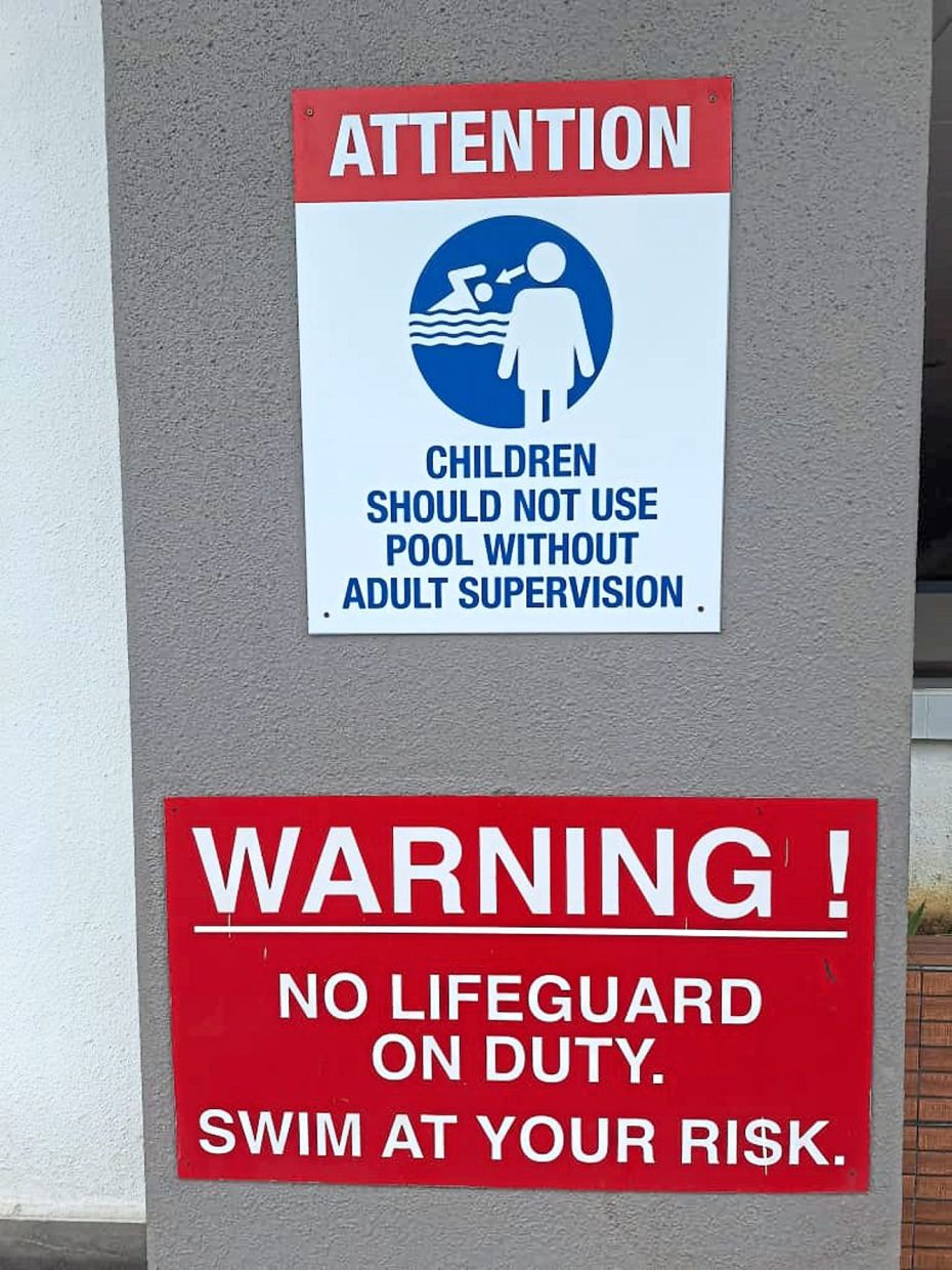 Signs at a condominium warning users of the risks of leaving children unattended and swimming without a lifeguard on duty.