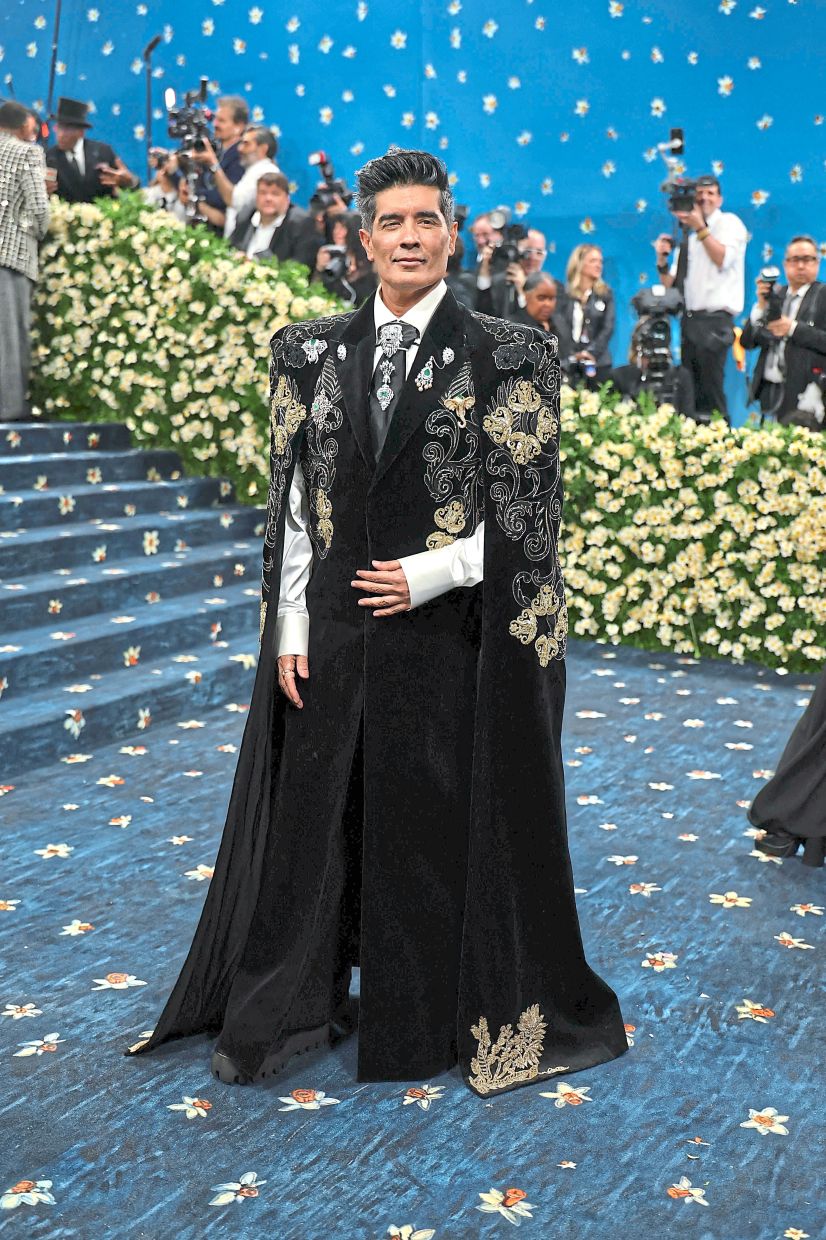 Designer Manish Malhotra wears an elaborate embroidered cape coat over a silk shirt and intricately detailed tie. Photo: AFP