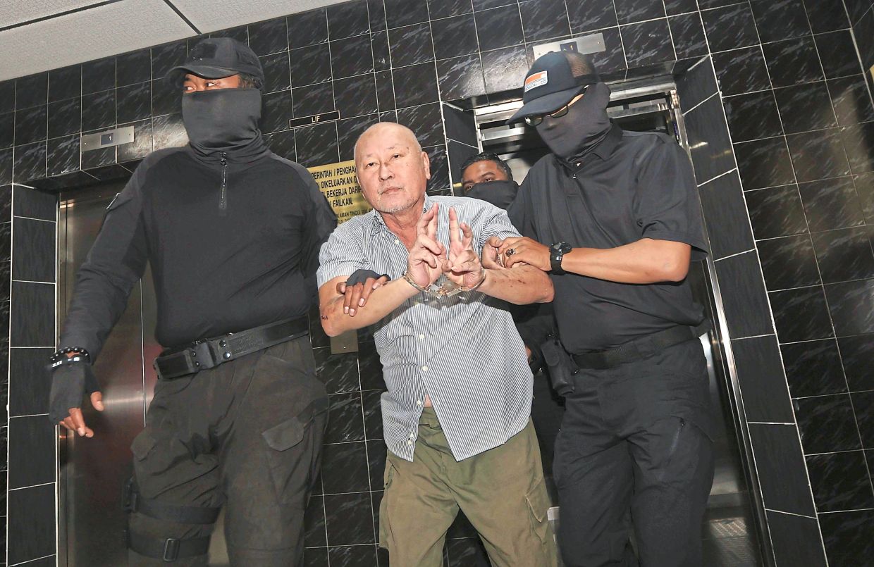 Gesture for the media: Yee showing the peace sign as he is taken to Butterworth Court. — ZHAFARAN NASIB/The Star