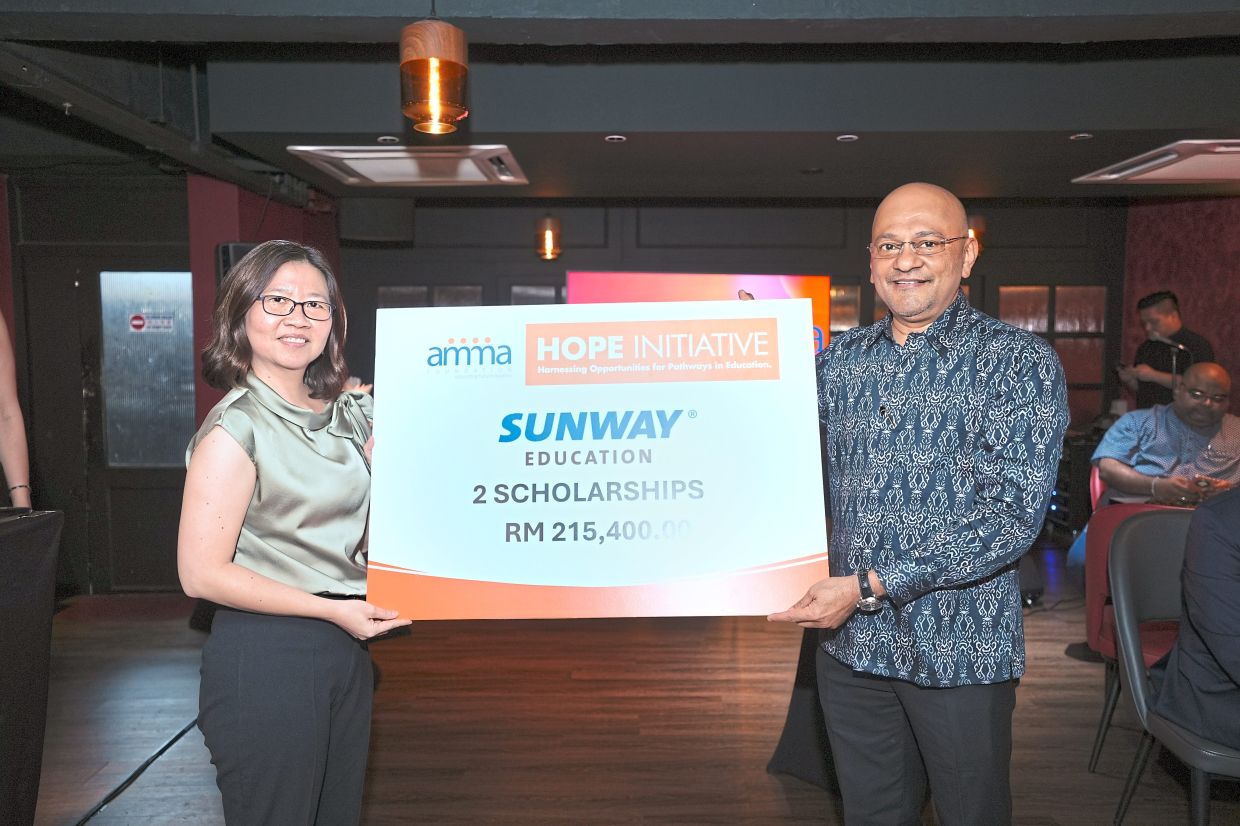 Sunway University head of scholarship and student life Soo Ee Sarn making a symbolic presentation of scholarships to Surendran.