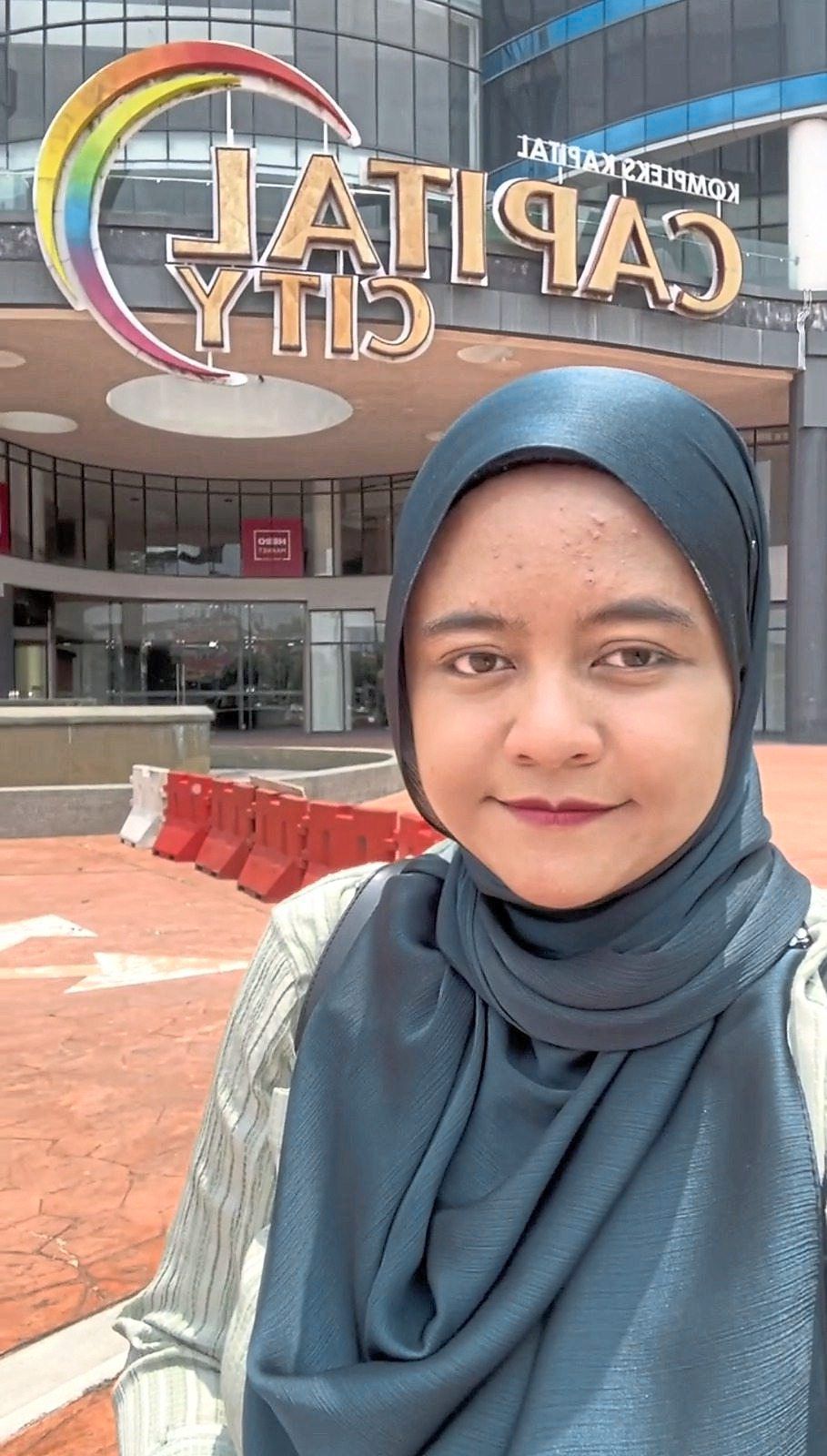 Nur Hamiza in front of Capital City, an abandoned mall in Johor Baru.