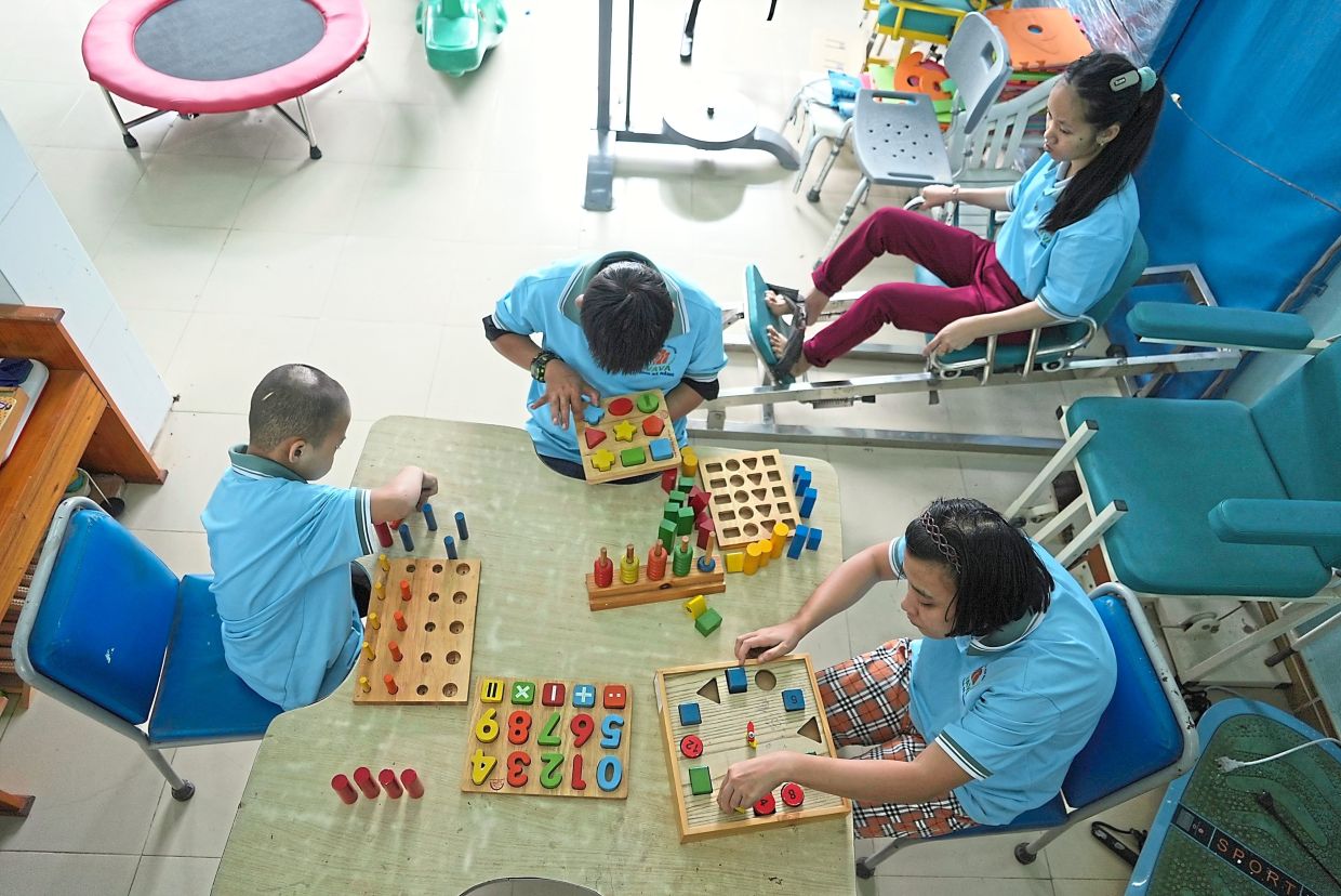 Still feeling the effects: Students playing with wooden blocks in physiotherapy class at a school for victims of Agent Orange in Da Nang. — AP