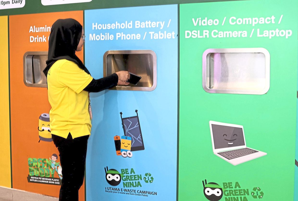 Recycle for a good cause: Ainina Azmi recycling her old mobile phone at a recycling centre in 1Utama shopping centre, Petaling Jaya. — ART CHEN/The Star