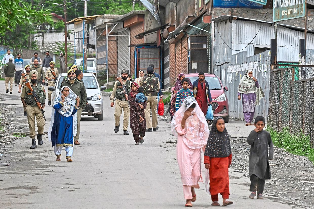 Seeking shelter: Indian villagers evacuating following overnight Pakistani artillery shelling in Uri. — AFP