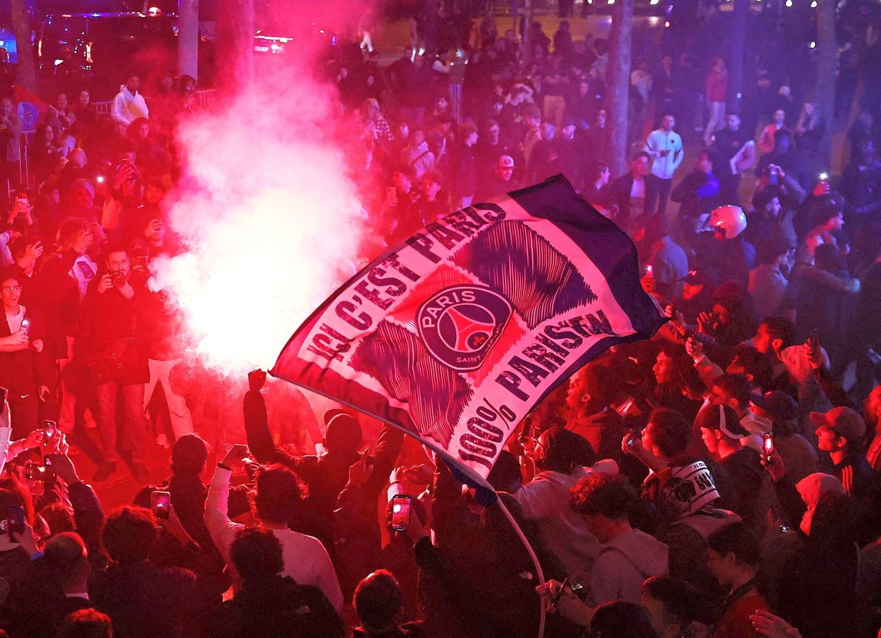 Paris St Germain fans celebrate near the Champs Elysees avenue after their team reached the final. — Reuters