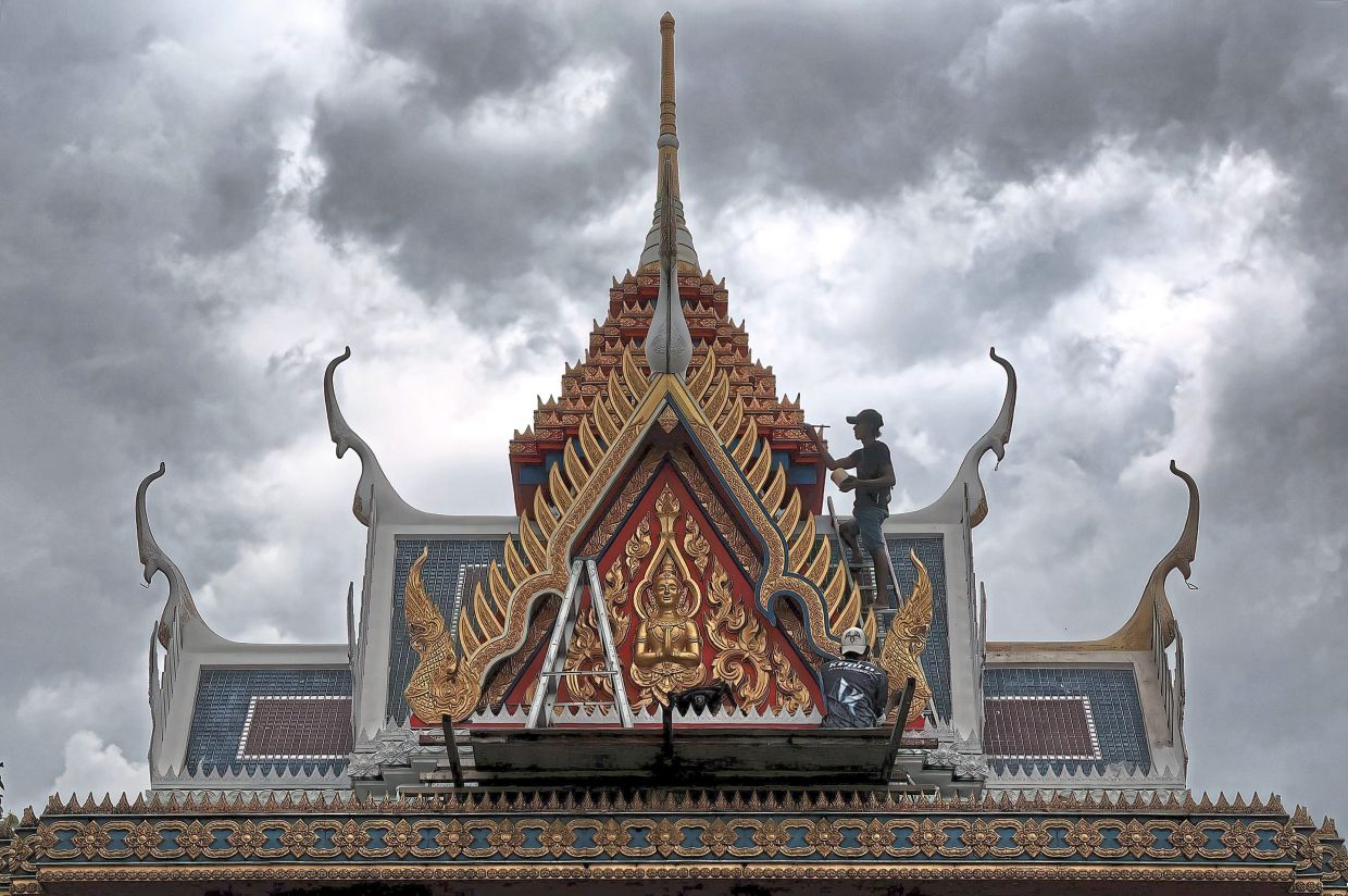 Workers busy sprucing up the temple facade, cleaning up ceremonial areas and setting up tents in preparation for Wesak Day at the Thai Buddhist Chetawan Temple in Petaling Jaya, Selangor.