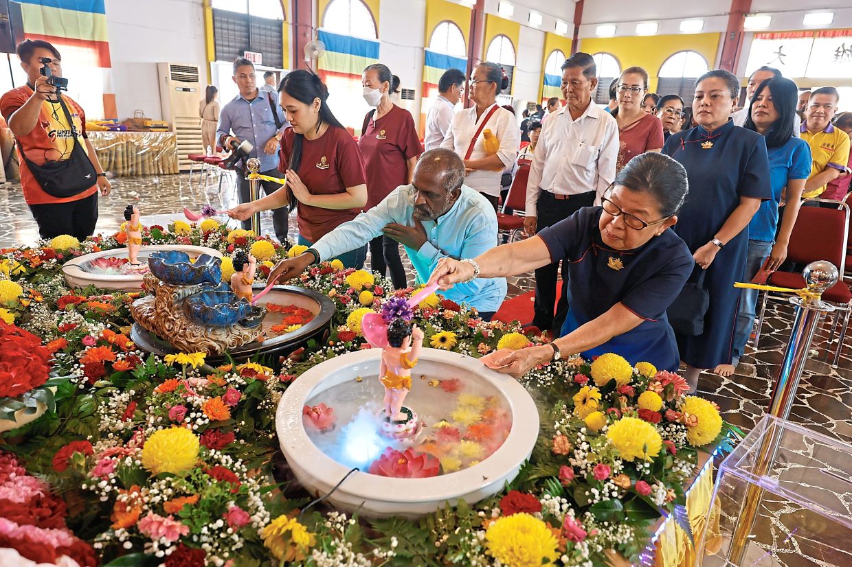 Act of devotion: People participating in the Buddha statue-bathing ritual at the Sarawak Buddhist Association, Kuching. — ZULAZHAR SHEBLEE/The Star