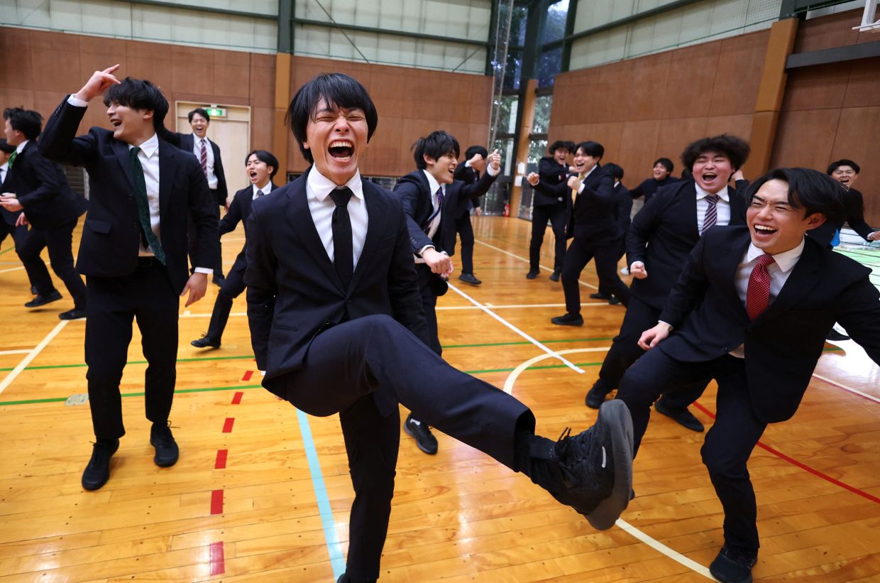 Satoi Mochizuki, 32, laughs with his teammates of Cheer Re-Man's as they practise their routines. - Reuters