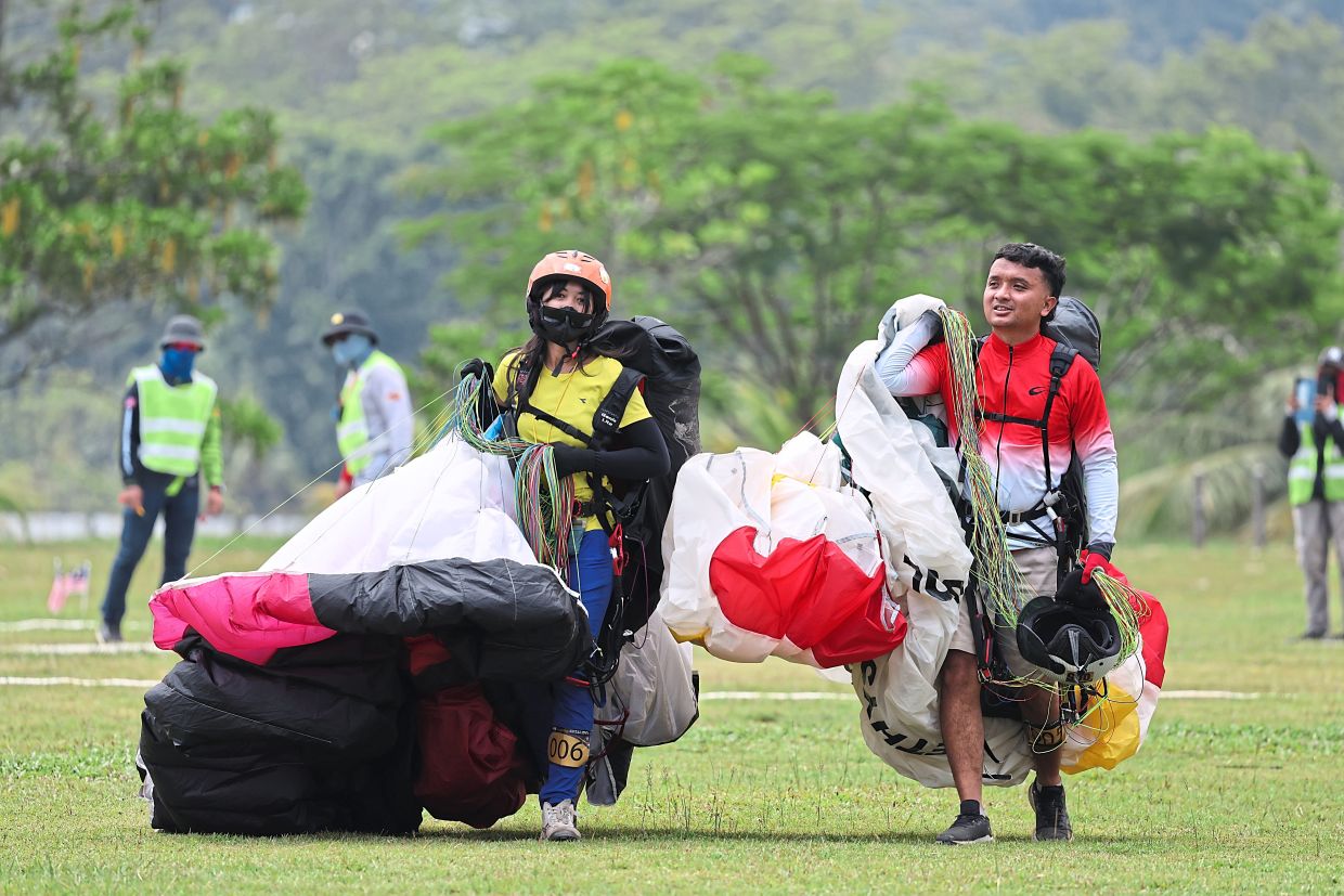 Enthusiasts with with their parafoil after a successful descent.