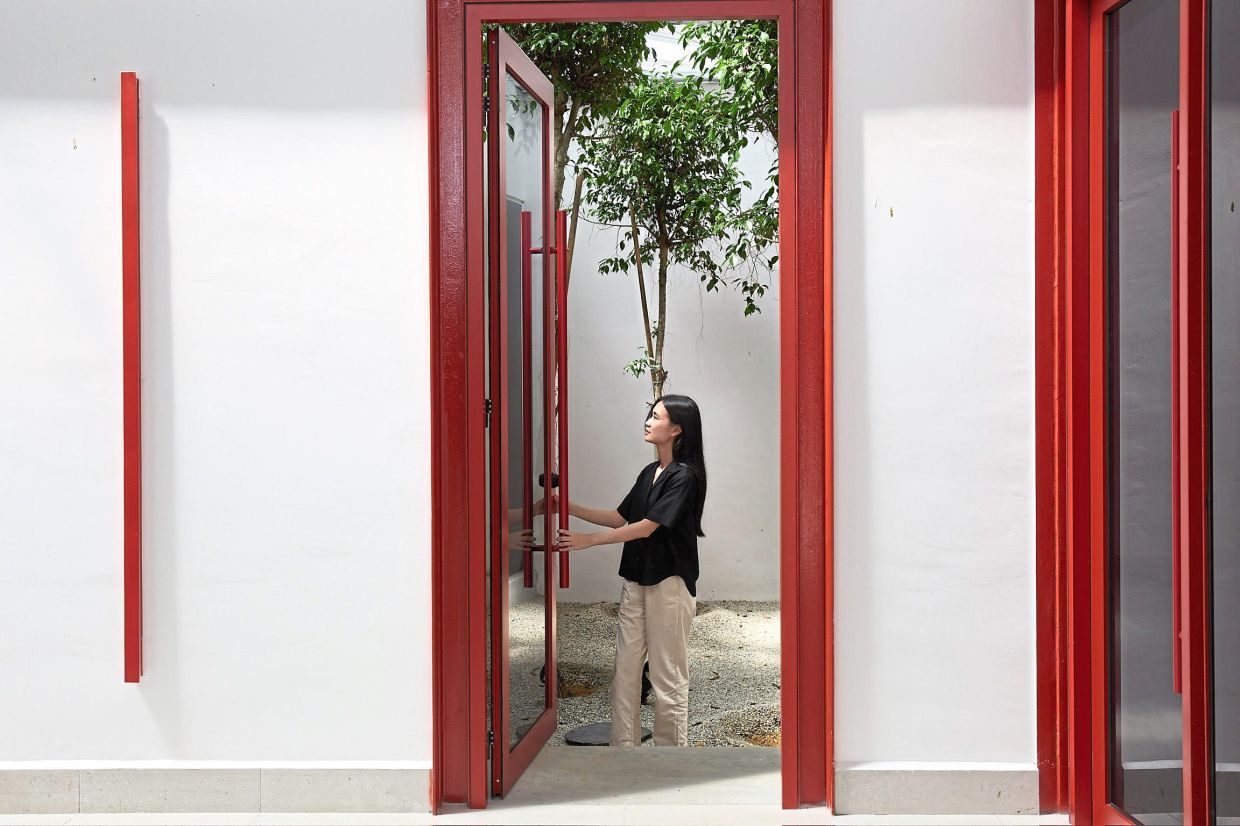 Red metal frames, neutral grey walls and greenery are part of the project’s colour palette. Photo: A3 Projects/Arch Cubica Architects (Malaysia)