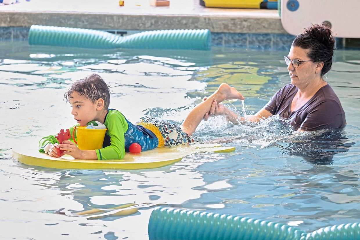 Occupational therapist Angelina Price from The Learning Center guides a student in the water. Photo: BEN RUSNAK/Children’s Services Council of Palm Beach County/AP