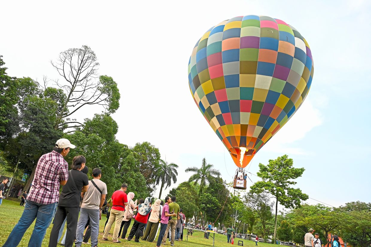 Visitors lining up for the hot air balloon ride at Dataran Kemerdekaan in Shah Alam. — Photos: IZZRAFIQ ALIAS/The Star
