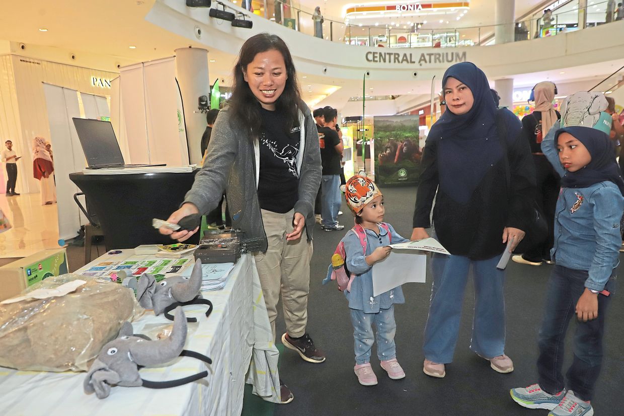 Dr Wong (left) with visitors at a booth displaying elephant-themed merchandise at the roadshow held at Aman Central Mall in Kedah.