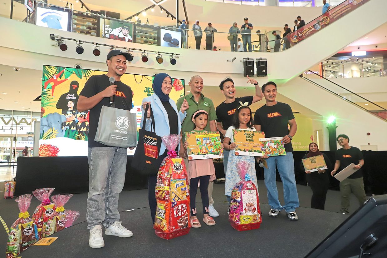 DJ Lin (second from left), along with several Suria FM DJs and a representative from MPOGCF presenting prizes to winners of a colouring contest at the roadshow.