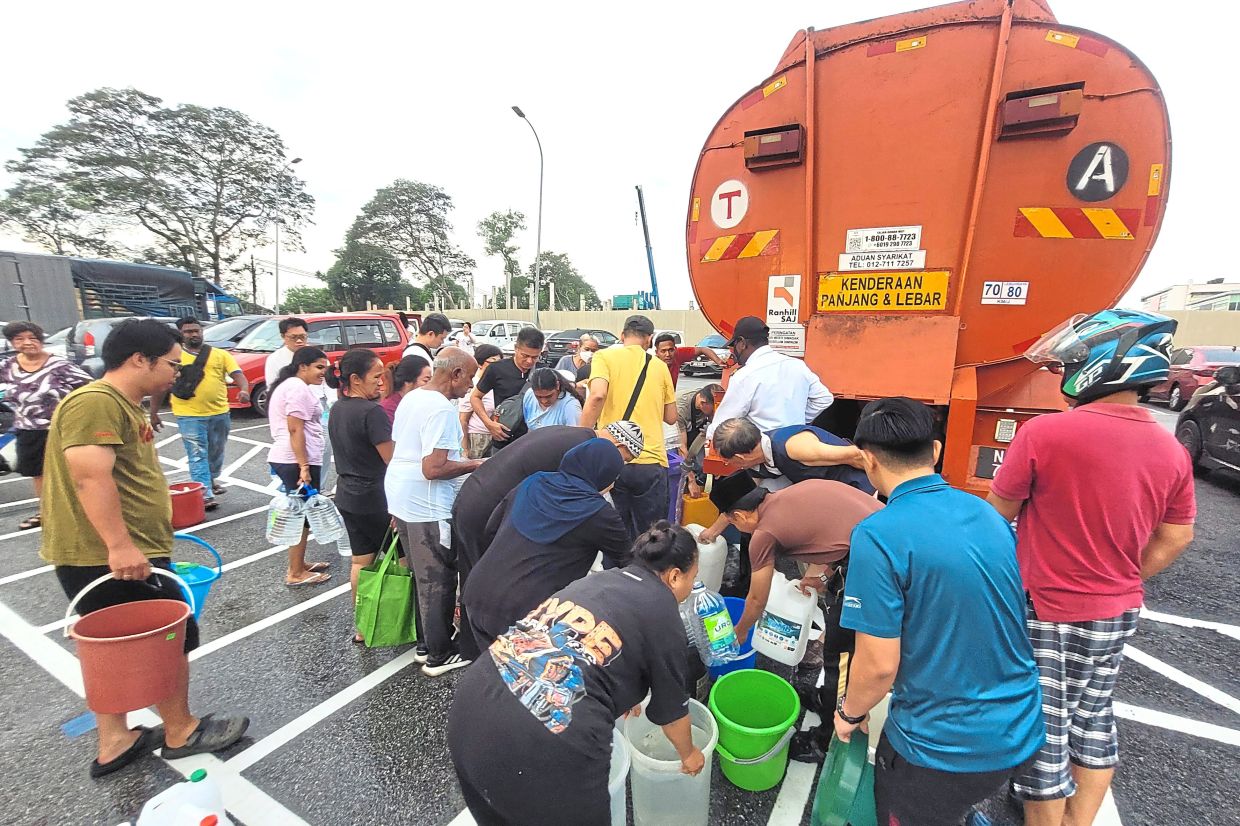 Residents lining up to get water from a tanker near Perling market in Johor Baru during the recent unscheduled disruption. — Filepic