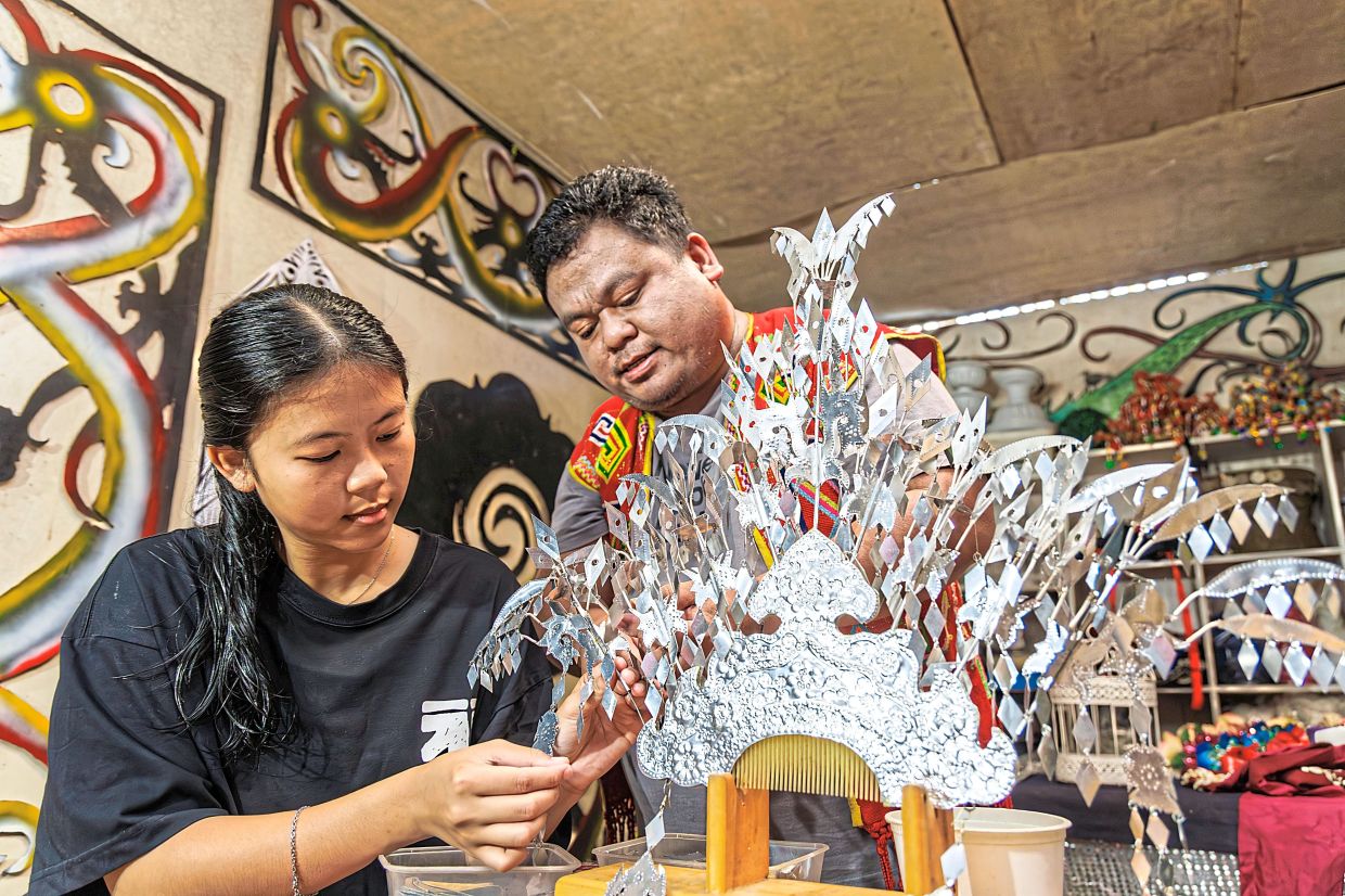 Louis and his sister Almanda, 19, putting the final touches on a sugu tinggi, ensuring every detail is just right.