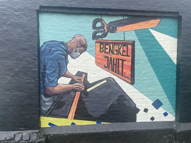 One of the panel with the mural showing a inmate working inside one of the workshops.