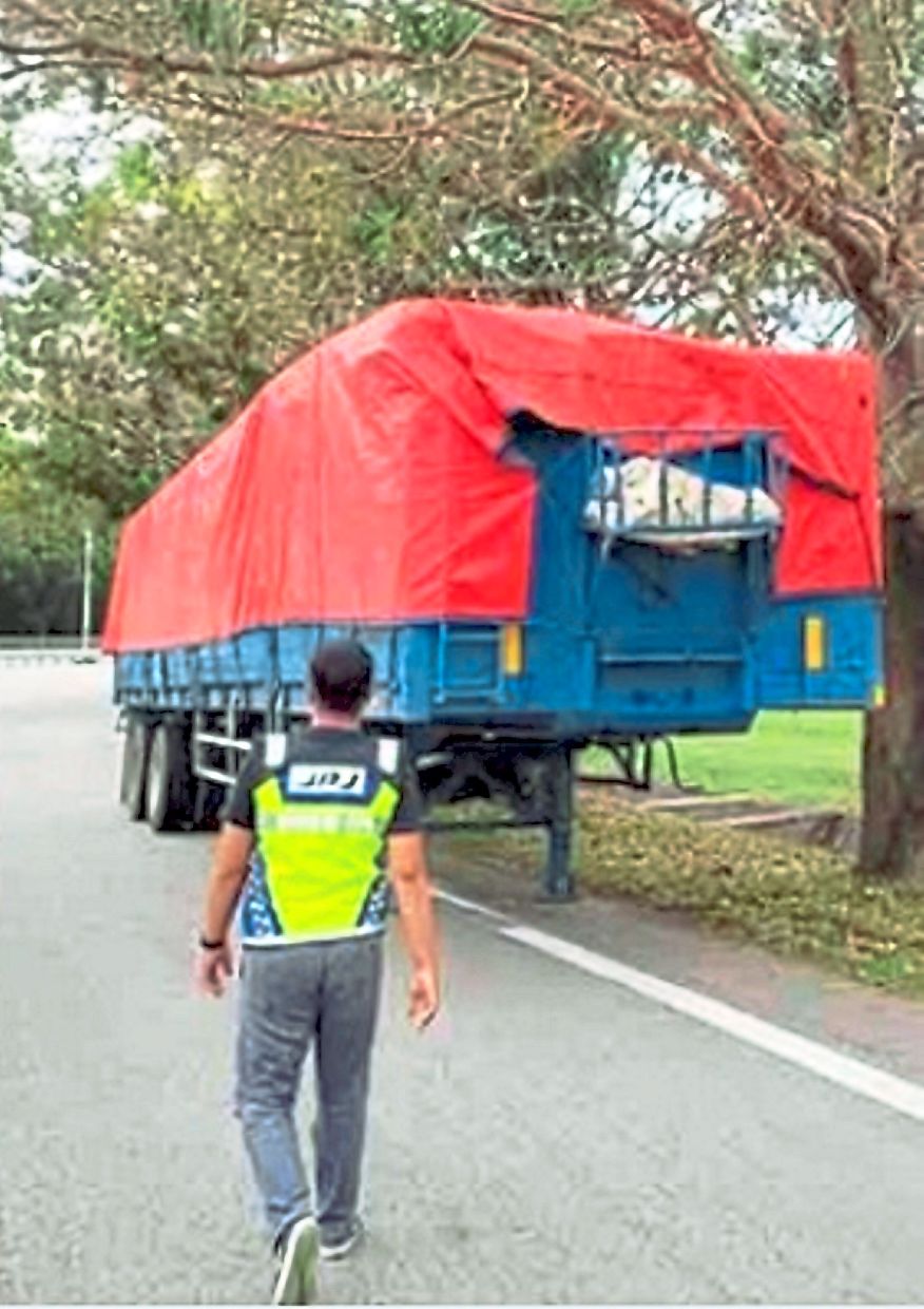 A JPJ officer taking a closer look at one of the lorries along the SKVE toll plaza.