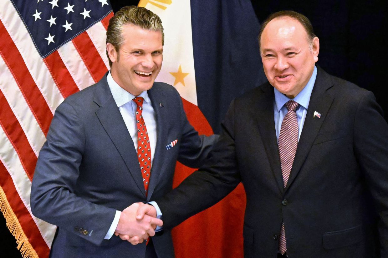 US Secretary of Defense Pete Hegseth (left) shakes hands with Philippines' Secretary of National Defense Gilberto Teodoro (R) before a bilateral meeting on the sidelines of the Shangri-La Dialogue Summit in Singapore on Friday, May 30, 2025. -- Photo by MOHD RASFAN / AFP