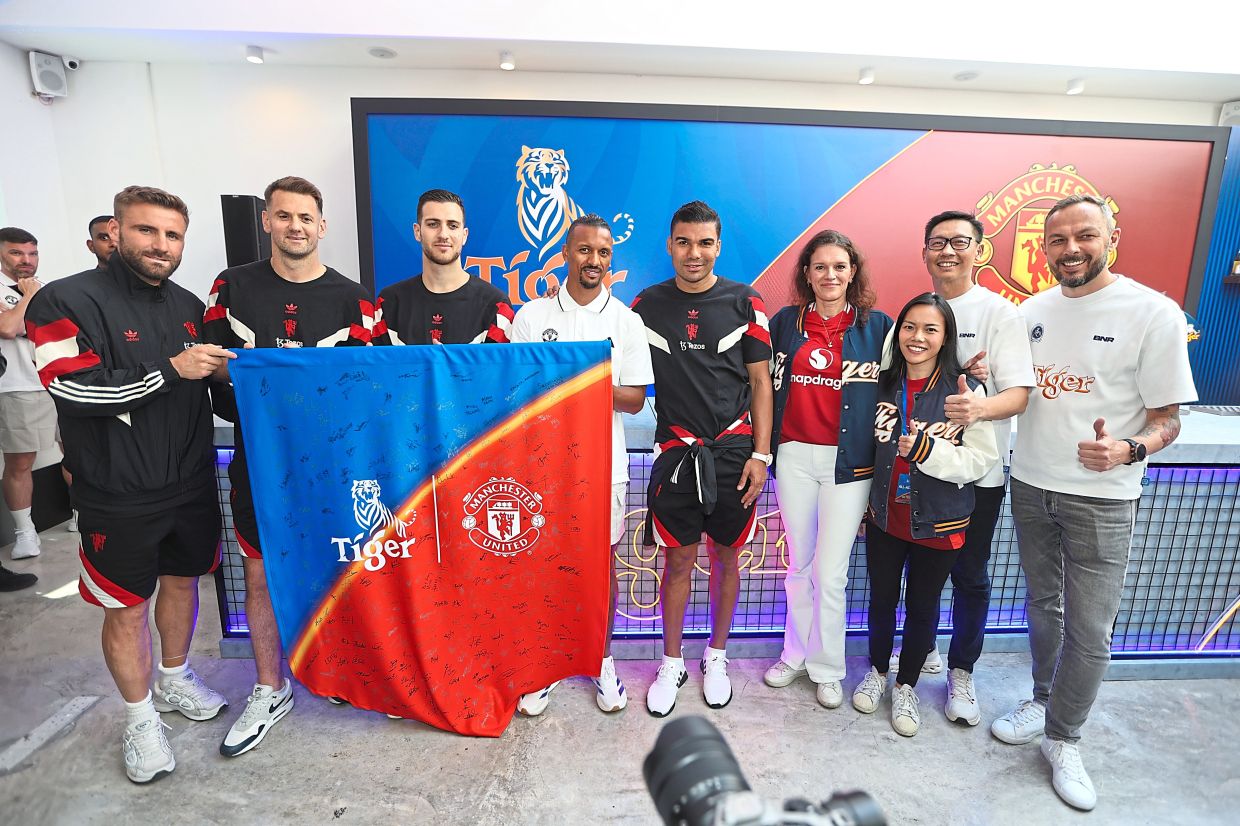 (From left) Shaw, Heaton, Dalot, Nani, Casemiro and Sneep with the banner signed by fans.