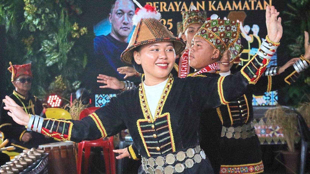 A dancer in traditional costume performing during the Kaamatan event.