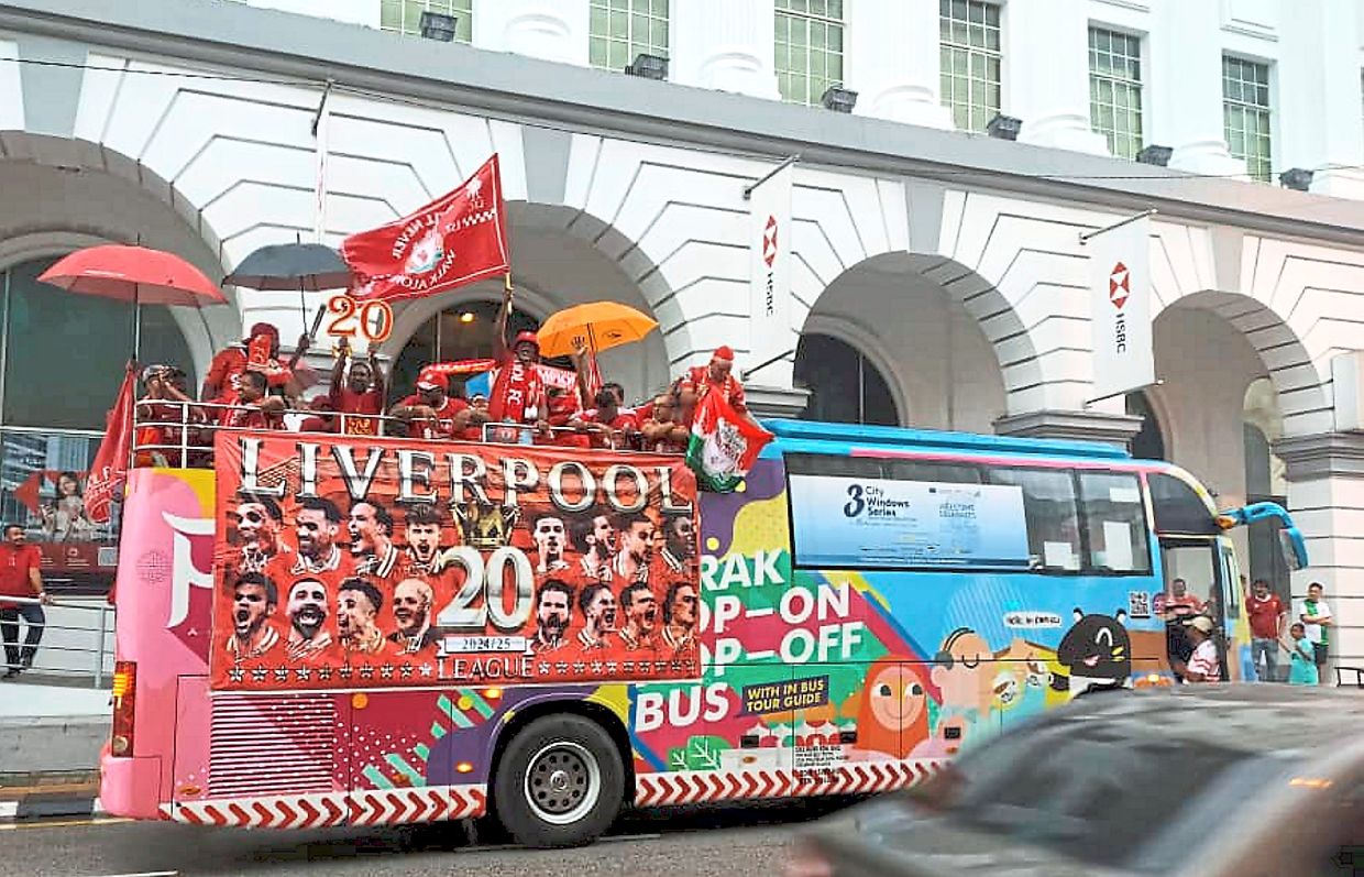 The open-top bus with supporters driving through Ipoh to celebrate Liverpool’s 20th English Premier League title win.