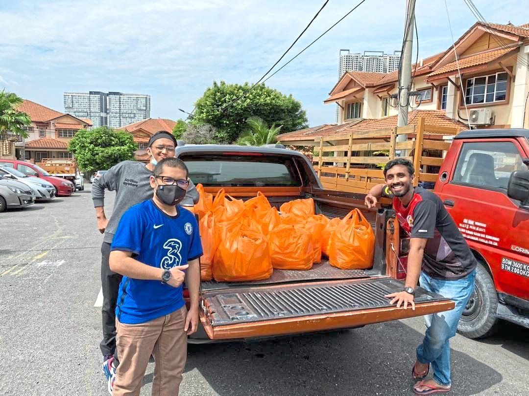 Thashidaran (right) and other volunteers preparing to distribute food to the needy in the Klang Valley.