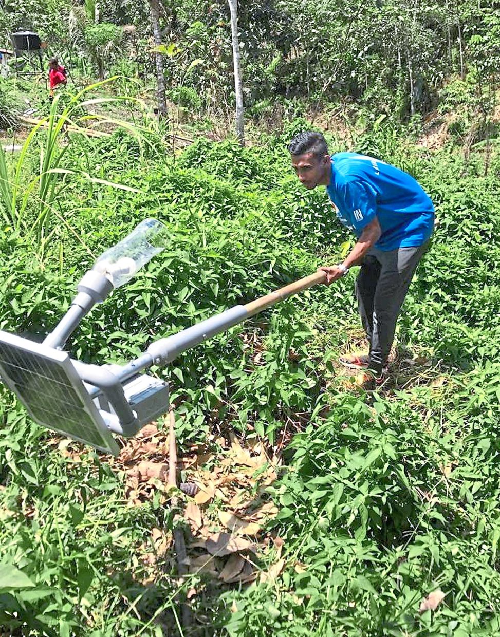 Thashidaran helping to install solar power panels in an Orang Asli village in Cameron Highlands.