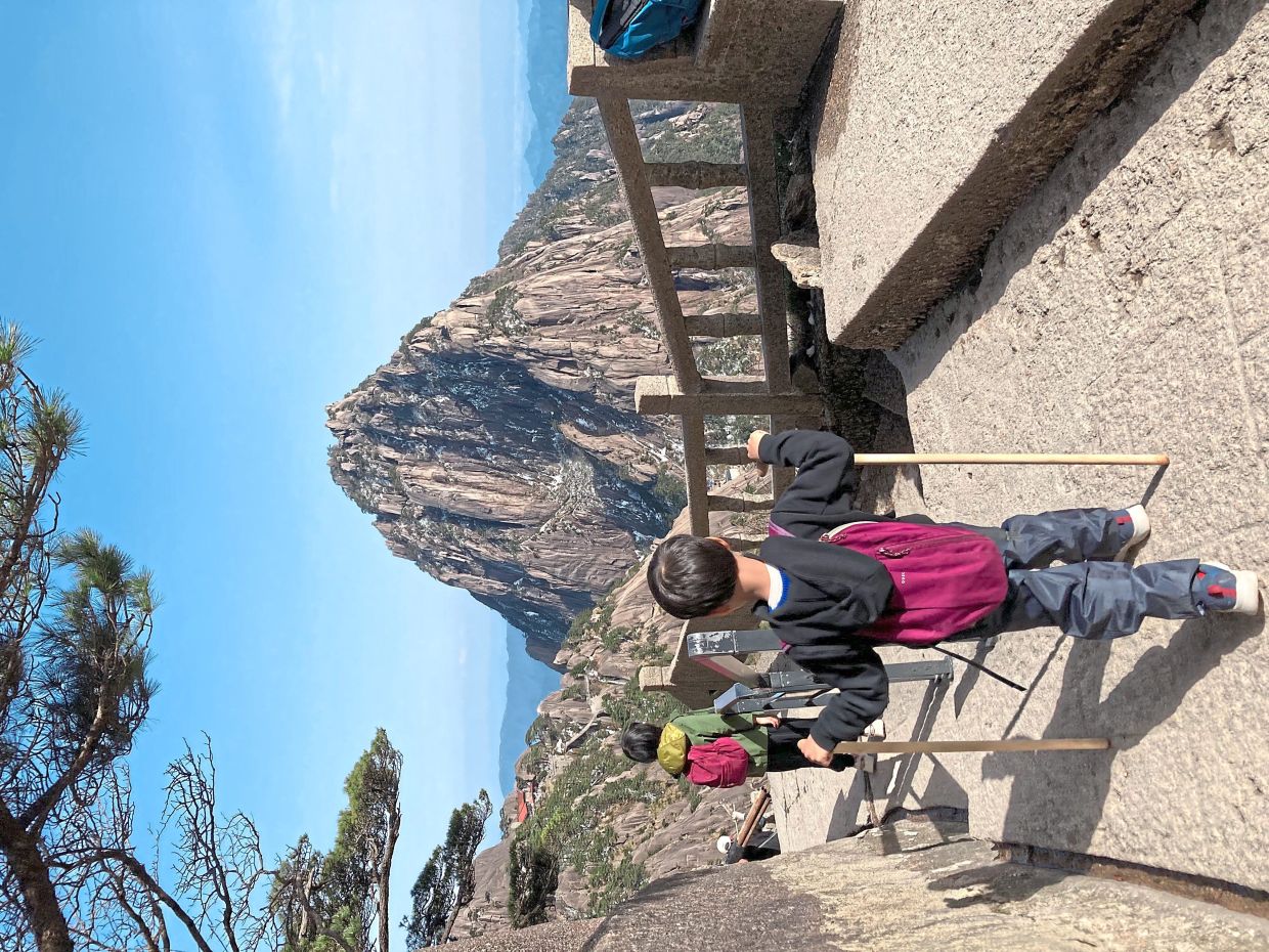 The writer’s young children leading the way with the magnificent Tiandu Peak in front.