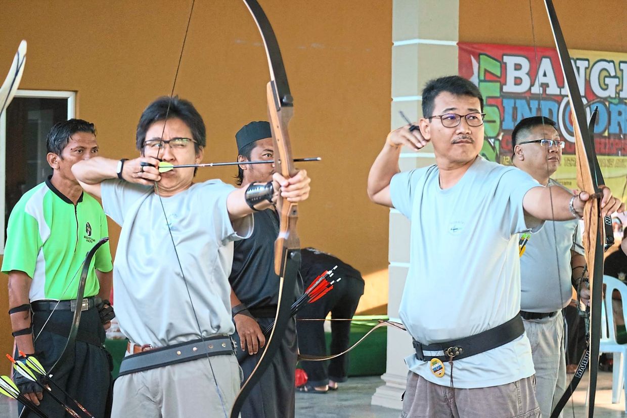 Archers competing at a local tournament with a wooden takedown Recurve bow and a Traditional Longbow.