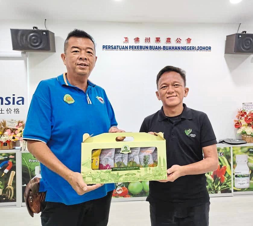 Lo (left) presenting a token to Muhamad Izad who shared about the incentives for young farmers.