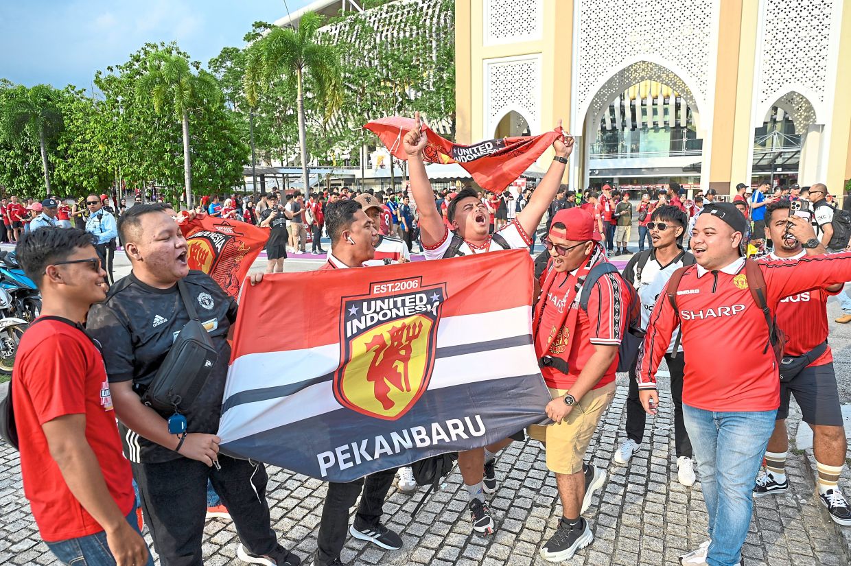 A group of die-hard Manchester United fans from Indonesia waiting to get into the Bukit Jalil National Stadium compound before the Maybank Challenge Cup match.