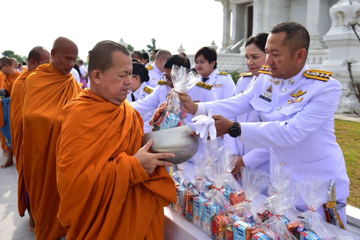 Civil servants offers alms to Buddhist monks to celebrate the 47th birthday of Thai Queen Suthida Bajrasudhabimalalakshana in Narathiwat in southern Thailand on Tuesday, June 3, 2025. -- Photo by Madaree TOHLALA / AFP