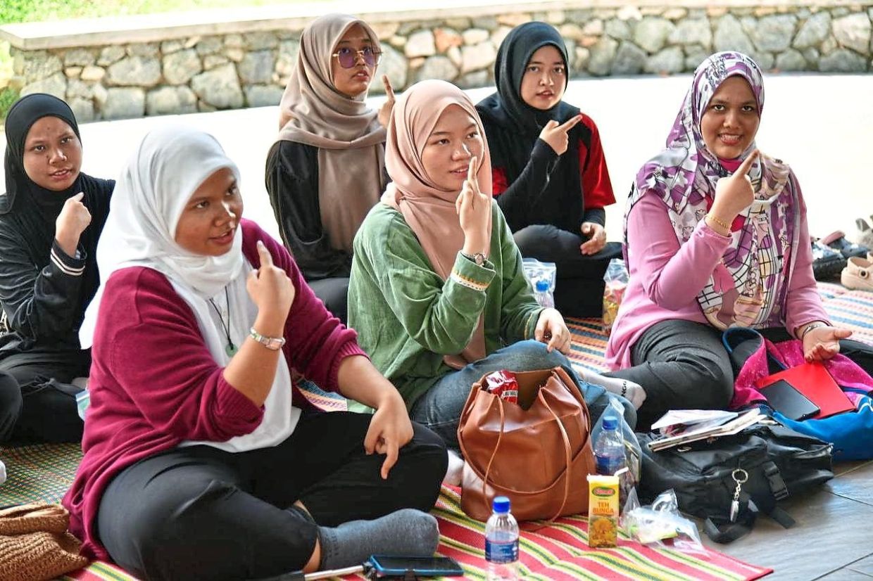Participants learning sign language during the ‘Johor Baru Story Time’ programme organised by the Sultan Ismail Library at the Johor Baru Tunku Mahkota Ismail Youth Centre.