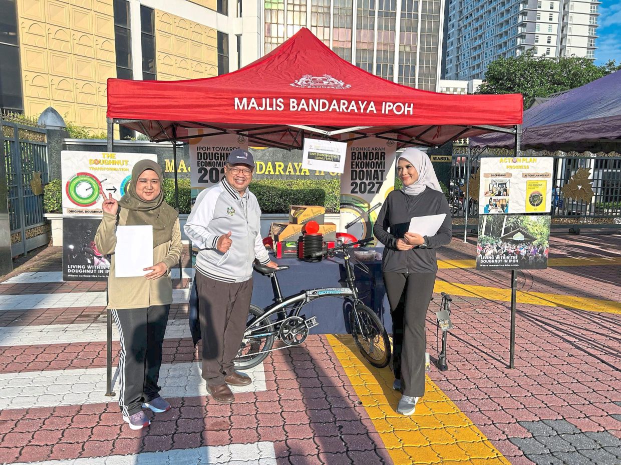 Zulqarnain (centre) explaining the Doughnut Economics concept to the public during Ipoh’s Low-Carbon Day event held at Dataran Ipoh.